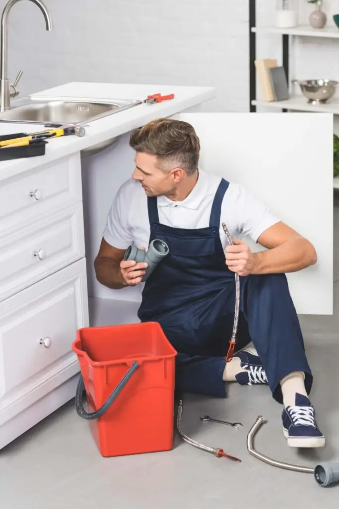 adult repairman with red plastic bucket holding pi 2024 11 15 00 54 07 utc 1